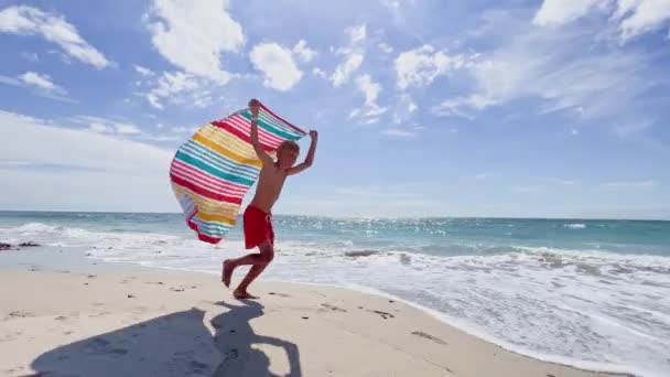 Близкий Портрет Мальчика Бегущего Цветной Парашютной Тканью Камере Над Морем — стоковое видео