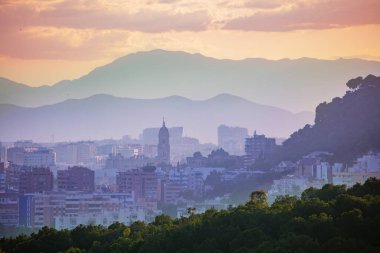 Şehir merkezindeki günbatımı manzarası ve Malaga Katedrali dağ sıraları üzerinden, güney İspanya 'daki Endülüs kale duvarlarından.