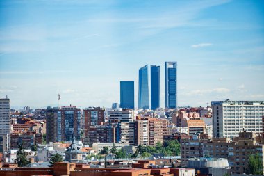 Madrid Dört Kuleler İş Bölgesi ya da Cuatro Torres 'in ön plandaki konut binaları üzerindeki şehir manzarası