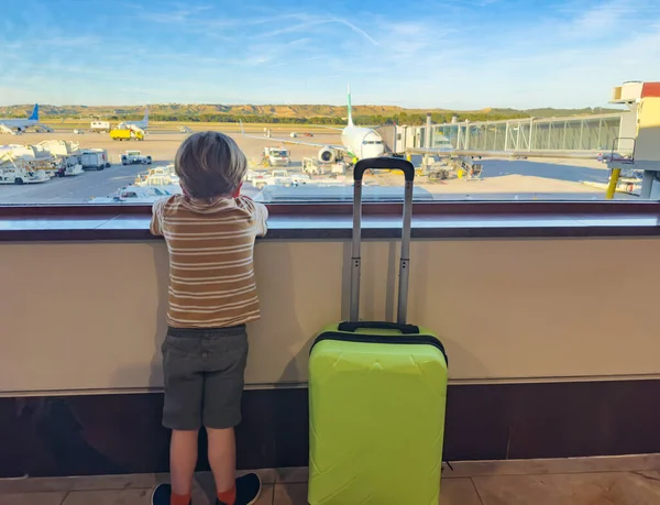 Małe Dziecko Stoi Lotnisku Zieloną Walizką Czekającą Samolot Przy Bramie — Zdjęcie stockowe