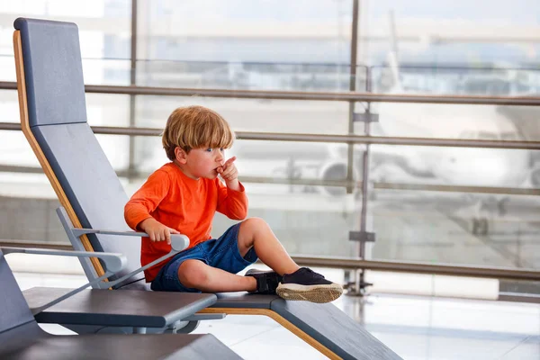 Liten Pojke Vänta Flyget Sitta Stolen Flygplatsen Lunge Tittar Flygplan — Stockfoto