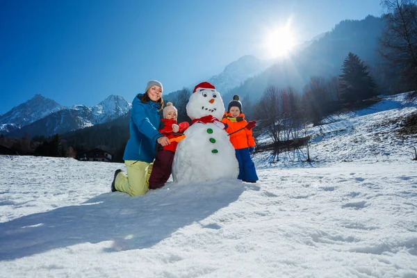 Mutlu Anne Küçük Çocuklar Kızla Birlikte Dağlarda Kardan Adam Yapıyorlar — Stok fotoğraf