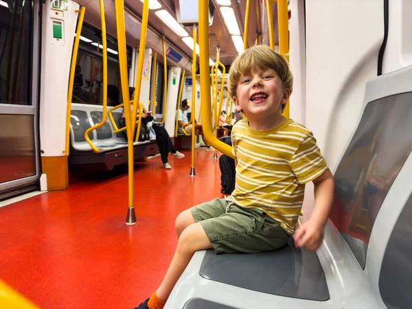 Küçük çocuk Madrid metrosunun treninde, yaralı arabanın altında kameraya mutlu bir şekilde gülümsüyor.