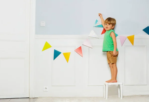 Little Blond Boy Look Camera Put Colorful Party Pennants Chain — Stock Photo, Image