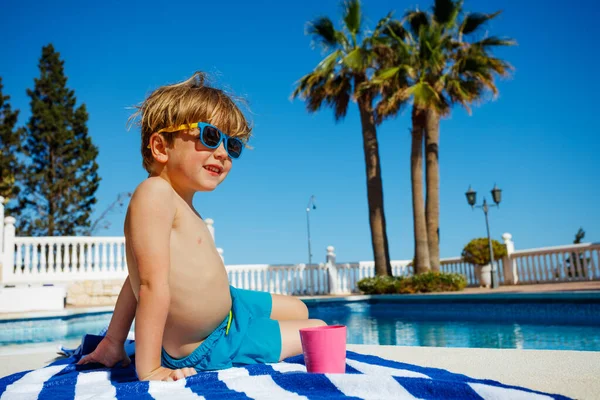 Liten Glad Pojke Sitter Nära Poolen Solglasögon Randig Handduk Med — Stockfoto