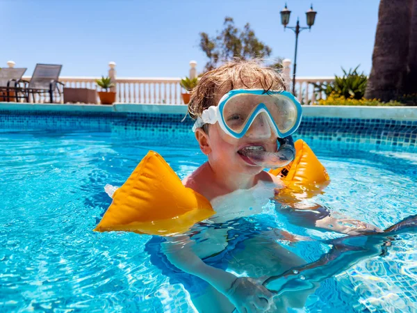 Χαρούμενο Ξανθό Αγόρι Μάσκα Κολύμβησης Και Βραχιόλια Επιπλέουν Στην Πισίνα — Φωτογραφία Αρχείου