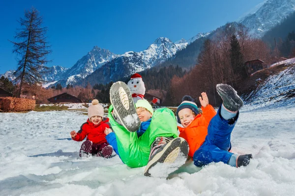 Szczęśliwe Dzieci Chłopcy Dziewczyna Skakać Śniegu Zabawy Zewnątrz Przez Bałwana — Zdjęcie stockowe