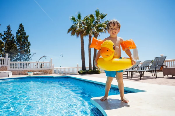 开开心心的孩子 戴着一只小鸭浮标和黄色的小花 准备跳入蓝天的水池里 — 图库照片