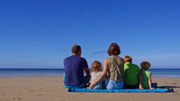 Çocuklu Bir Aile Kumsalda Bir Arada Oturur Ellerini Arkadan Kaldırır — Stok video