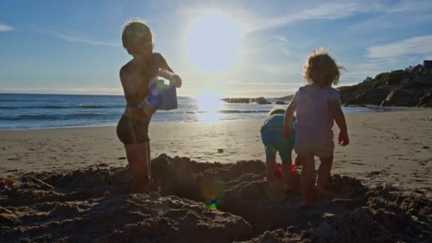 Crianças Brincam Com Areia Praia Oceano Sobre Ondas Surfistas Passando — Vídeo de Stock