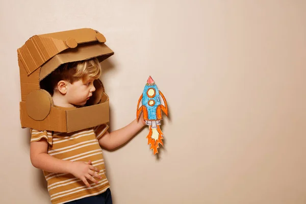 Un niño con casco de astronauta de cartón sostiene el planeta tierra  Fotografía de stock - Alamy