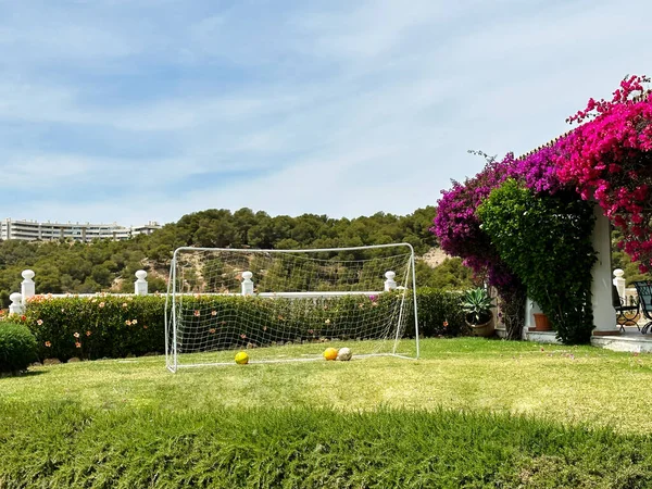 西班牙南部房子附近草坪上的足球大门 网里有很多球 — 图库照片