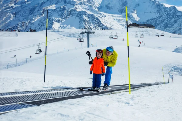 寒假期间 小男孩和父亲在滑雪场上滑行 在滑雪场上边走边看高山 — 图库照片