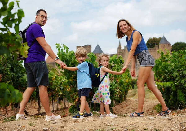 Glückliche Touristenfamilie Steht Neben Weinreben Und Schaut Die Kamera Mit — Stockfoto