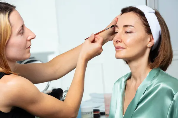 Kosmetikerin Tragen Wimperntusche Mit Augenbrauenbürste Auf Die Schöne Frau Mittleren — Stockfoto