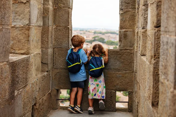 两个带着背包的小男孩和小女孩的小游客探索了法国卡卡松内要塞的石塔 — 图库照片