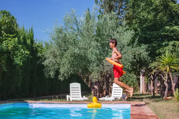 Joyful Boy Teen Red Shorts Runs Swimming Pool Carrying Orange — Stock Photo, Image