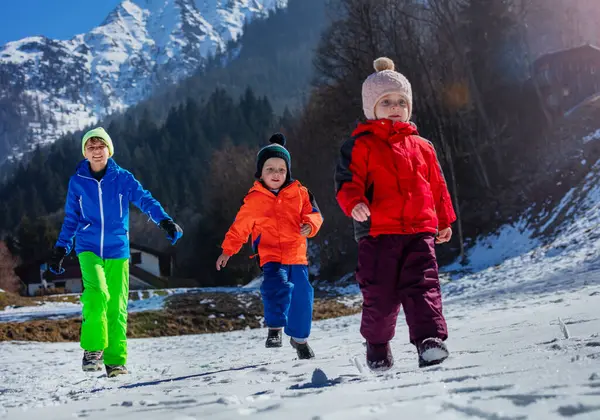 Action Shot Happy Siblings Run Mountain Village White Snow Showy — Stock Photo, Image
