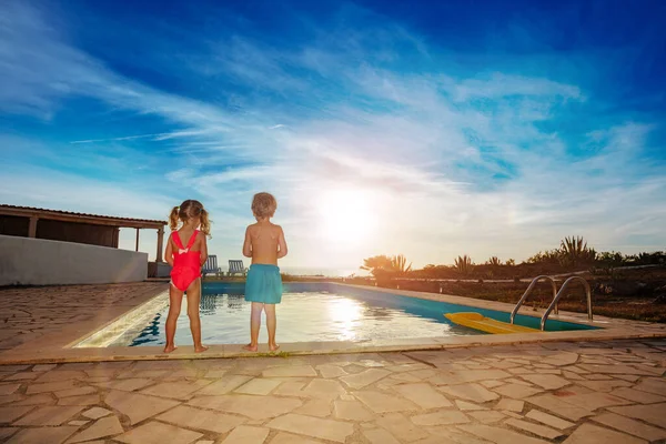 Two Young Children Standing Edge Swimming Pool Watch Evening Sun — Stock Photo, Image