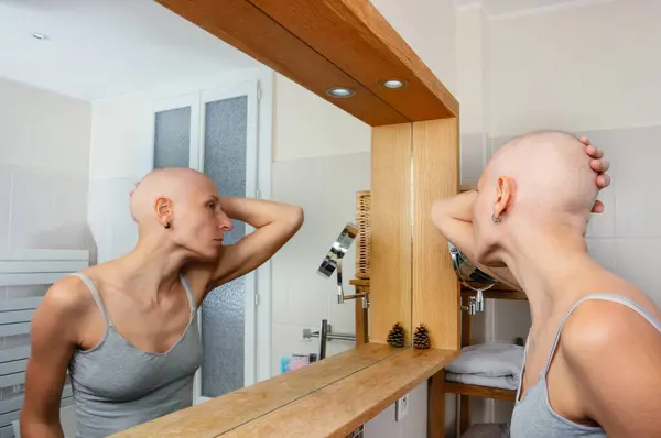 Задумчивая Лысая Женщина Борется Раком Рассматривает Свое Отражение Зеркале Светящемся — стоковое фото