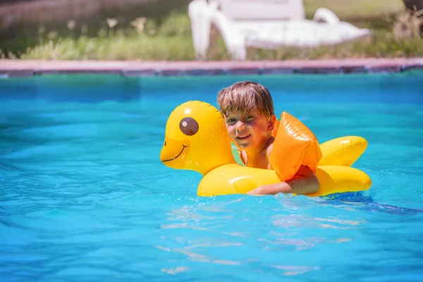Menino Pequeno Aprecia Playtime Aquático Pato Inflável Seus Braços Suportados Imagem De Stock