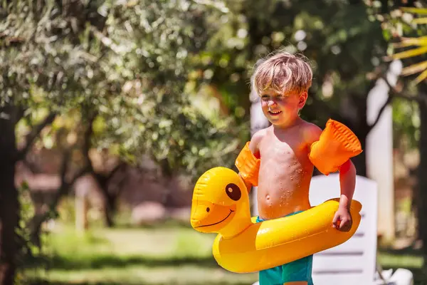 Fröhlicher Kleiner Junge Bereit Seinem Entchenförmigen Schwimmring Rande Eines Klaren lizenzfreie Stockbilder