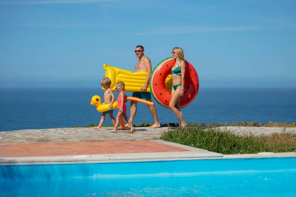 Een Echtpaar Met Hun Kinderen Wandelen Langs Het Zwembad Zich Stockafbeelding