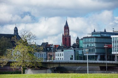 Hollanda 'nın Maastricht kentsel manzarası modern binaların üzerinde yükselen Kızıl Kule ile çeşitli mimari yapılar sergiliyor.