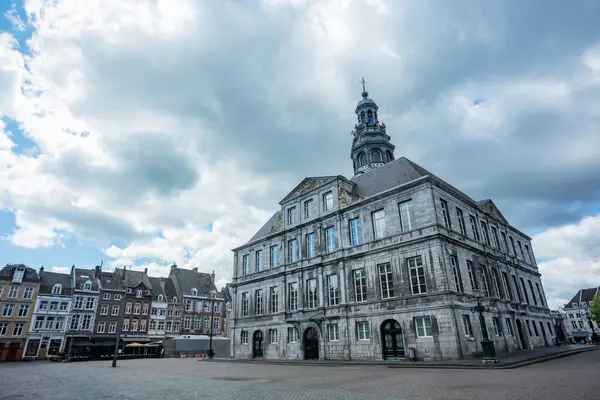 Bulutlu bir günde, Maastricht, Hollanda 'da saat kulesi olan bir belediye binasının klasik mimarisi.