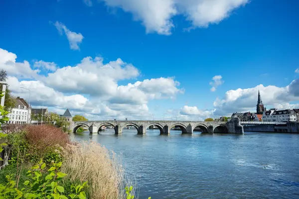 Hollanda 'nın Maastricht şehrinde Meuse Nehri' nin durgun sularının üzerinde duran büyüleyici yaşlı Sint Servaas köprüsü