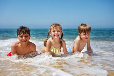 Sörf ve kumların heyecanını yaşayan çocuklar yaz tatillerinde neşe dolu sıçramalarla kaplanırlar.