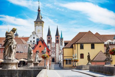Wurzburg 'daki eski bir katedralde, açık bir günde, Mainbrucke, Bavyera, Almanya' dan manzaralı, canlı bir caddenin ortasında iki çan kulesi yükselir.