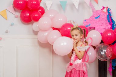 Mutlu yıllar balon şişiren kızlar, etrafta bir sürü süsleme var.