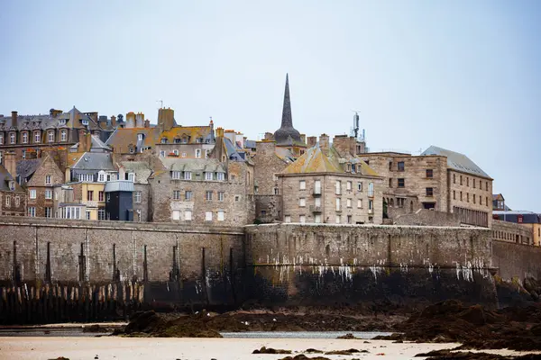 Kıyı şeridi boyunca genişleyen bir plaja ve bulutlu ufuklara, Saint-Malo 'ya, Bretagne' a, Fransa 'ya karşı sayısız geleneksel bina kurulmuştur.