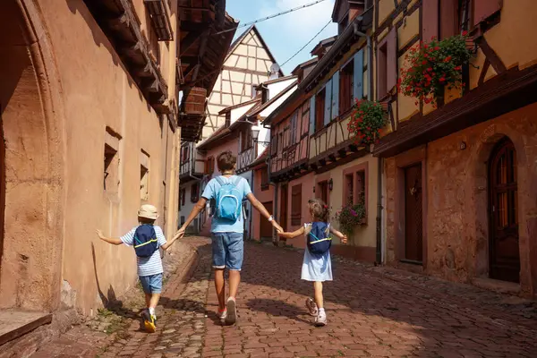 Avrupa, Alsace bölgesi ve Fransa 'nın büyüleyici mimarisi tarafından çevrelenmiş, el ele tutuşarak manzaralı bir yolda yürüyor.