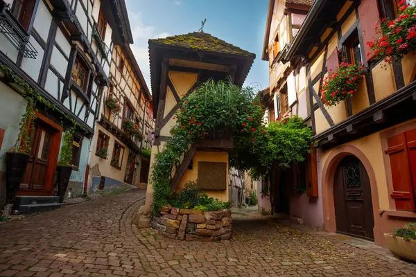 Manzaralı tarihi bir manzara, canlı çiçek sepetleri ve bol yeşilliklerle süslenmiş ahşap binalar, bir masal kitabı köyünde geçiyor.