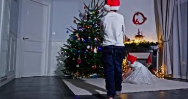 Çocuklar hediyeleri açmak ve paylaşmak için güzel dekore edilmiş bir ağaca koşarken neşeli bir neşe.