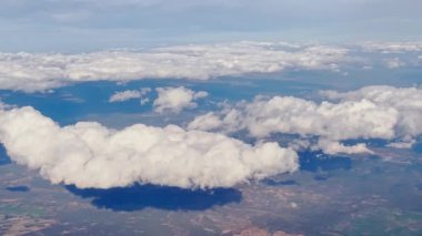 Yumuşak bulutlar dağ manzarasında sürükleniyor, yumuşak gölgeler bırakıyor.