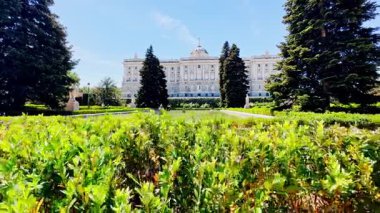 Parlak yeşilliklerle çevrili etkileyici bir saray. Güneşli göklere doğru yükselen yüksek ağaçlarla.