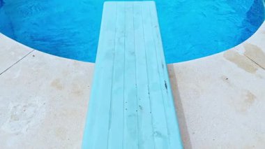 Dalış tahtası yazın ferahlatıcı mavi yüzme havuzuna yol açar.