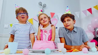 Genç bir kızın dilek tuttuğu bir doğum günü partisi sahnesi. Mumları üflerken, etrafında şapkalı iki çocuk alkışlıyor.
