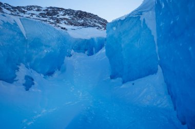 Her iki tarafında büyük, pürüzsüz mavi buzla donuk bir koridor, doğal buzulun güzelliği.