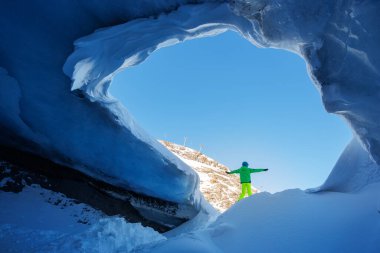 Mavi bir buz tabakasının altında, genç bir kayakçı antik buzulun mucizesini görmek için heyecanlanıyor.