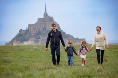 Aile, anne, baba ve iki çocuk Fransa 'daki Mont Saint Michel yakınlarında Normandiya' da serinletici bir yürüyüş sırasında kaynaşıyorlar.