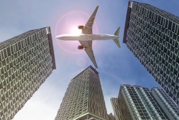 Flugzeug Fliegt Über Hochhäuser Mit Grellem Sonnenlicht Hintergrund Stockbild