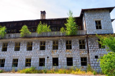 Unutulmuş bir otelin bu büyüleyici fotoğrafında terk edilmenin cazibesini keşfedin. Çürüyen dış görünüş ve aşırı büyümüş çevre zamanın geçişini ve doğanın ıslah edilişini vurgulayan unutulmaz güzellikte bir sahne yaratıyor. Onlar için mükemmel.