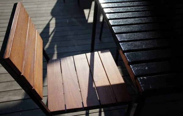 Holztische Und Stühle Auf Einer Von Der Untergehenden Sonne Beleuchteten — Stockfoto