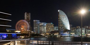 Japon liman kenti Yokohama 'daki kentsel binaların ve ışıkların gece görüşü                               