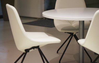 Odada beyaz sandalyeler ve masalar                               