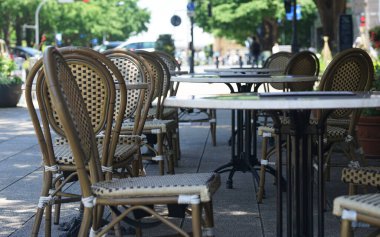Tables and chairs in a caf on a sunny city street                               